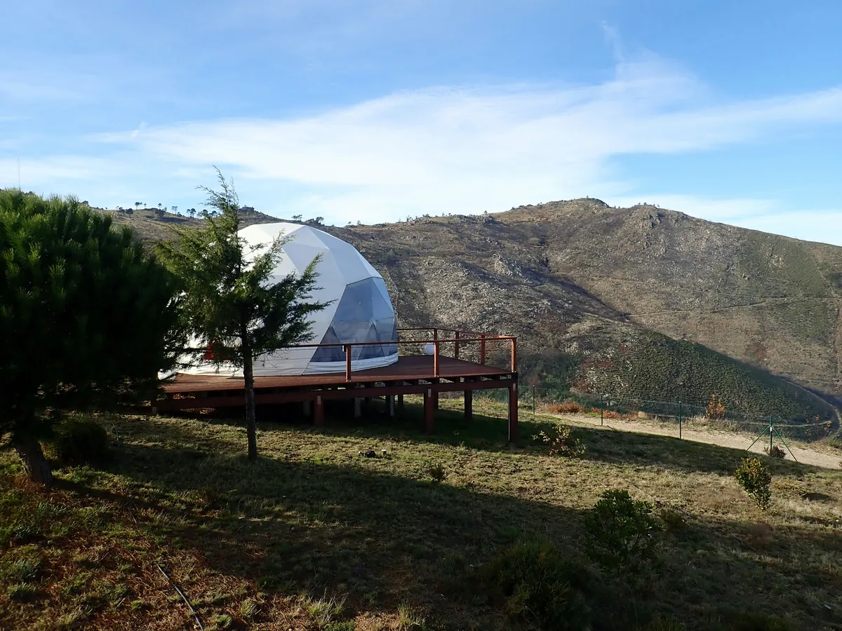 A white glamping dome on a wooden deck