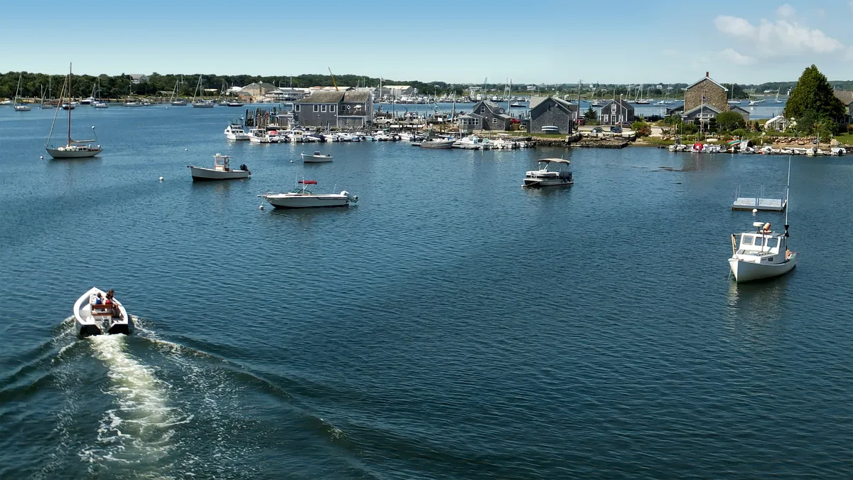Sailboats and powerboats on moorings in a harbor