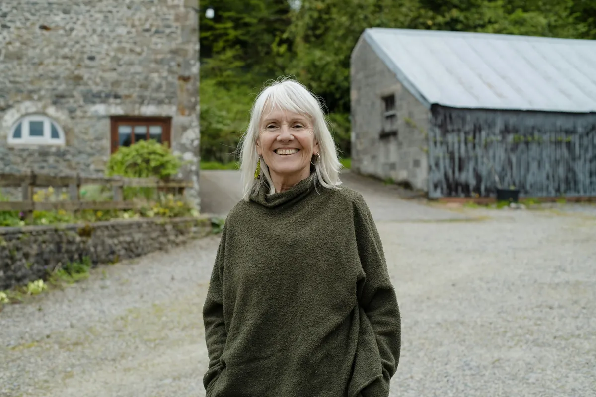 A smiling white-haired volunteer coordinator outdoors
