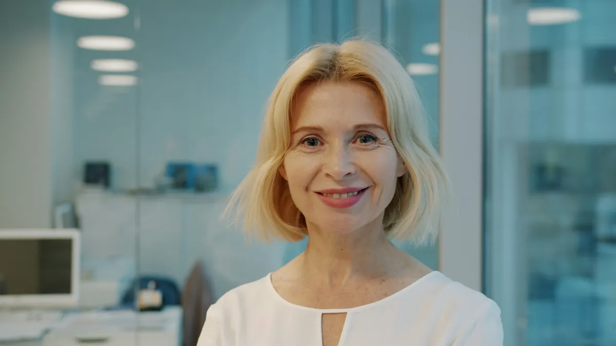 A smiling clerk in a white blouse in a bright office