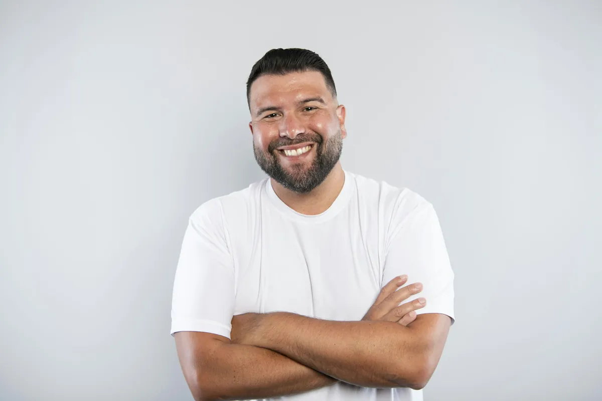 A smiling rental manager with a beard and crossed arms
