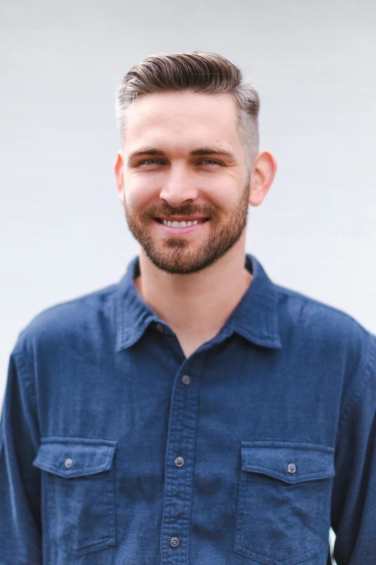 A smiling technician in a denim work shirt